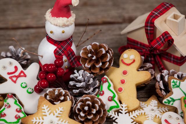 Festive Christmas decorations featuring a snowman with a Santa hat, gingerbread cookies, and pine cones. Ideal for holiday greeting cards, festive invitations, and seasonal marketing materials.