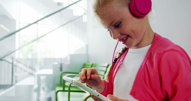 Young girl using digital tablet with headphones, enjoying technology indoors - Download Free Stock Images Pikwizard.com