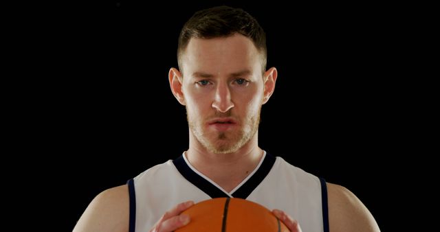 Focused Basketball Player Holding Ball Against Black Background - Download Free Stock Images Pikwizard.com