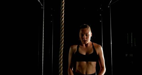 Female Athlete Climbing Rope in Fitness Studio