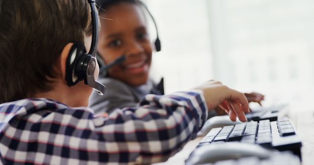 Two Children Wearing Headsets Using Computers, Smiling And Collaborating - Download Free Stock Images Pikwizard.com