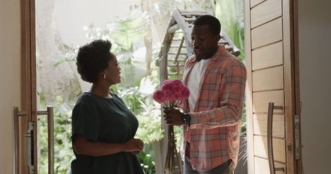 Friends Chatting with Pink Flowers Indoors