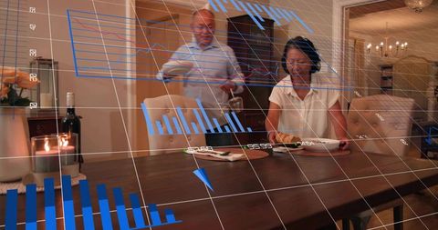 Mature couple dining while augmented reality charts floating over dining table