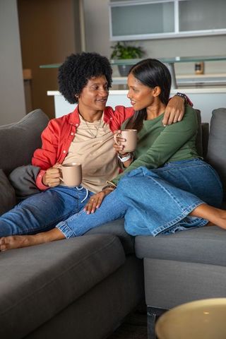 Diverse Couple Enjoying Relaxing Moment with Coffee in Cozy Living Room