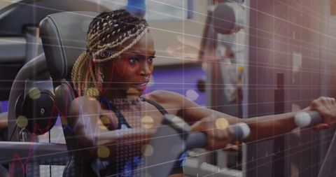 Woman with Braided Hair Using Chest Press Machine in Gym