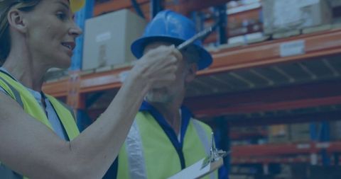 Warehouse workers in hard hats conducting inventory check