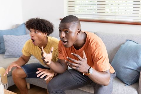 Excited Friends Grasping TV Show Intensity on Cozy Couch