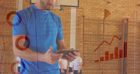 Coach Analyzing Sports Data on Tablet in Gym Environment