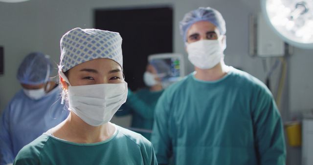 Image portrait of asian female surgeon in face mask smiling in operating theatre, with copy space. Hospital, medical and healthcare services.