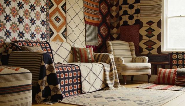 Bohemian living room layering vintage geometric throws cushions and patterned rugs for cozy decor