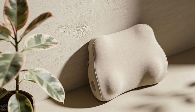Beige ergonomic neck massage cushion providing support and relaxation with woven texture