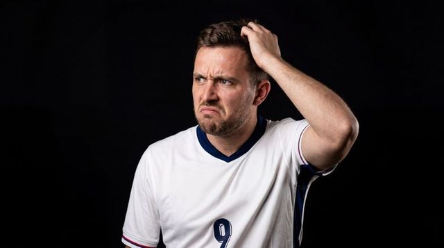 Perplexed soccer player scratching head wearing white number 9 jersey studio portrait
