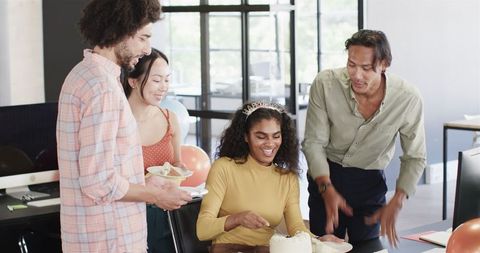Office celebration with birthday cake and diverse team