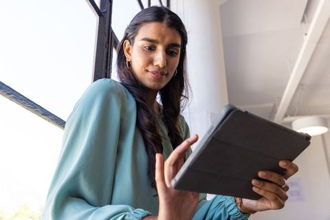 Professional woman holding tablet in modern office set-up