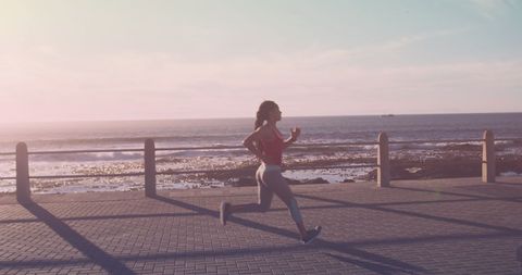 Energized Woman Running at Seaside Promenade
