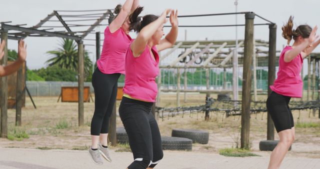 Diverse group of happy female friends cross training outdoors, jumping. Female fitness, challenge and healthy lifestyle.