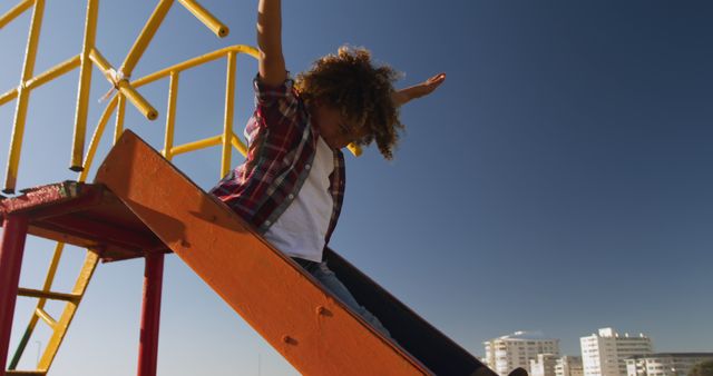 Child Sliding Down Playground Slide Under Blue Sky - Download Free Stock Images Pikwizard.com