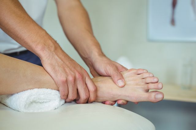 Physiotherapist massaging woman's leg in clinical setting. Useful for illustrating healthcare services, physical therapy treatments, wellness and relaxation techniques, and professional medical care.