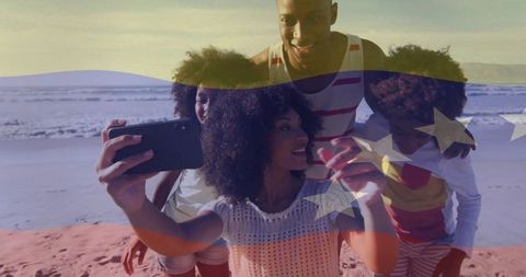 Family taking beach selfie with american flag overlay celebrating summer unity and joy