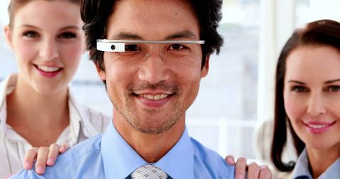 Businessman wearing smart glasses with colleagues in office setting