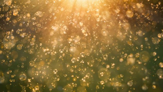 Sunlit golden bokeh droplets drifting through backlit air, glittering warm mist