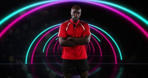 Powerful Athlete in Red Shirt Under Neon Arches Displaying Confidence