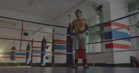 Shirtless boxer standing in ring preparing for sparring showing focus and discipline