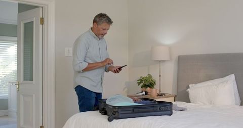 Senior adult preparing luggage for travel in bedroom