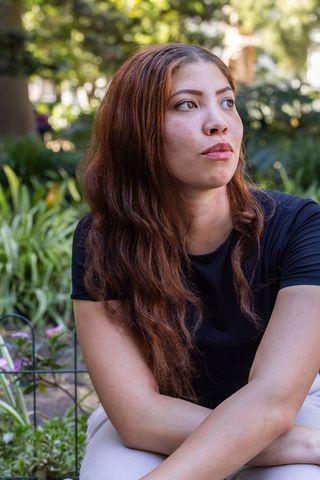 African american woman sitting in sunlit garden gazing upward contemplative calm
