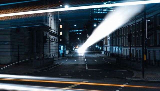 Nighttime urban long exposure with cutting headlight beam and streaking light trails