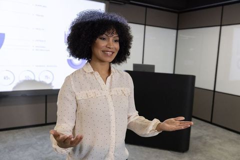 Confident Businesswoman Leading Corporate Presentation in Modern Office
