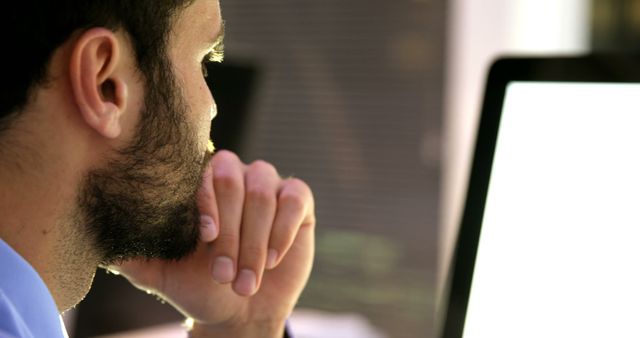 A young Caucasian man is focused on his computer screen, with copy space - Download Free Stock Photos Pikwizard.com