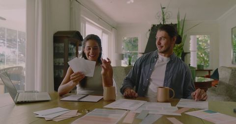 Couple planning wedding at home with coffee and laptop