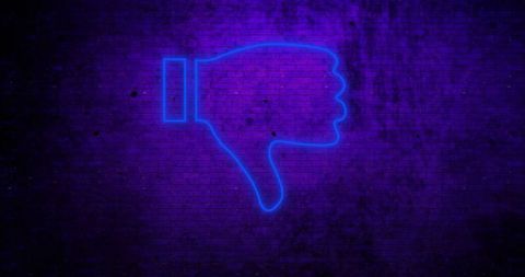 Neon blue thumbs down glowing on dark brick wall