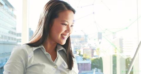 Asian Professional Woman Engaging with Laptop in Modern Office