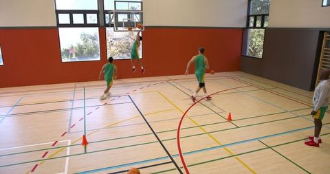 Basketball Team Training on Court with Slam Dunk Action