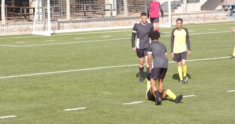 Soccer Player Celebrating Goal as Opponent Falls