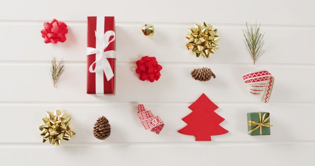 Top view of a white background adorned with Christmas gifts, decorative bows, pine cones, and small holiday ornaments. Excellent for holiday promotional materials, Christmas greeting cards, festive social media posts, or any seasonal advertising designs.