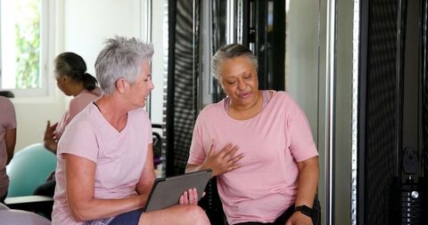 Senior women using tablet during workout session at home gym