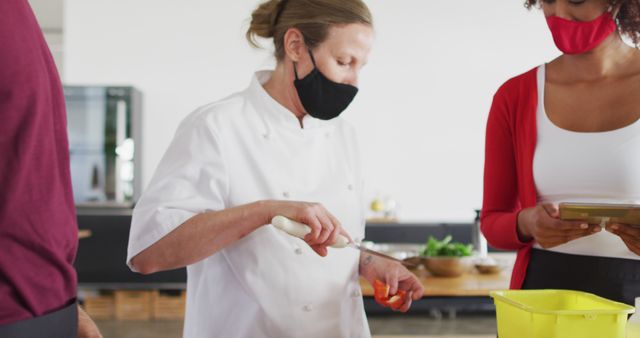 Chef preparing meal with team wearing masks in kitchen - Download Free Stock Images Pikwizard.com