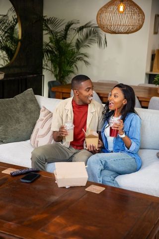 Couple Enjoying Takeout and Drinks at Home