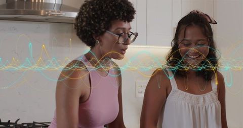 Friends cooking together in bright modern kitchen sharing recipe and laughter with soundwave overlay