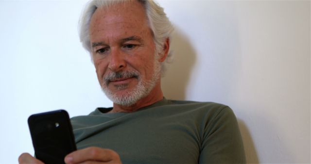 Older Man Using Smartphone at Home, Focused and Relaxed - Download Free Stock Images Pikwizard.com