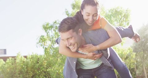 Joyful Couple Enjoying Outdoor Piggyback Ride in Sunshine - Download Free Stock Images Pikwizard.com