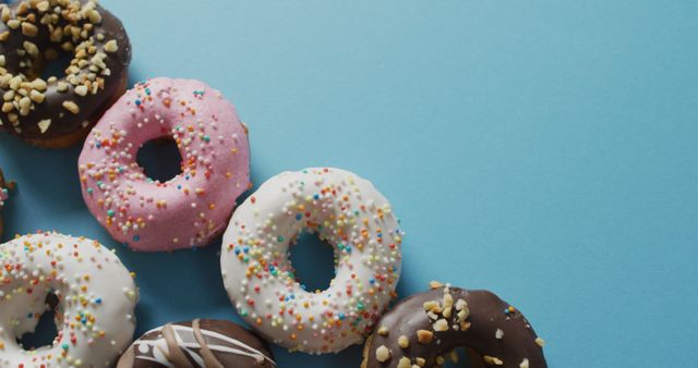 Assorted Colorful Frosted Donuts with Sprinkles on Blue Background - Download Free Stock Images Pikwizard.com