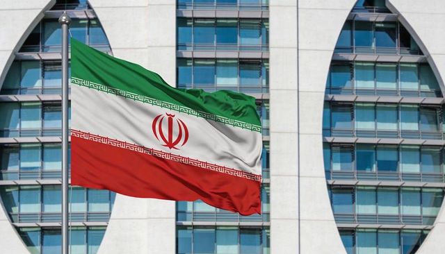 Waving iranian flag over modern government facade with tricolor emblem flying proud