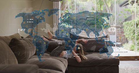 Child lounging on sectional sofa at home with futuristic world map overlay