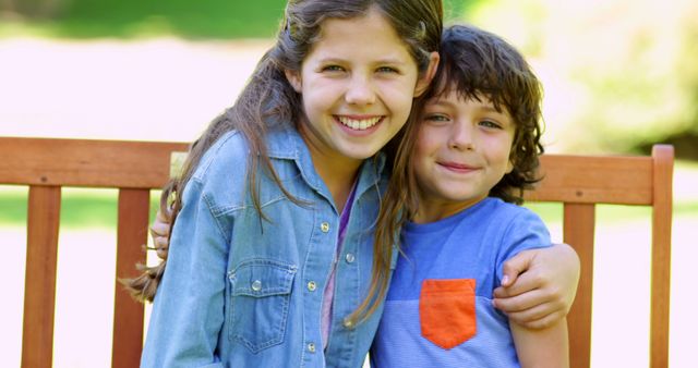 Smiling Siblings Hugging on Bench in Sunny Park - Download Free Stock Images Pikwizard.com