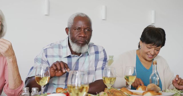 Elderly friends sharing a lively meal, showing bonding and togetherness. Image ideal for themes of friendship, community living, senior social events, and healthy lifestyle among the elderly. Perfect for use in health magazines, lifestyle blogs, community newsletters, and retirement living promotional materials.