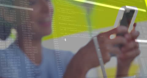 A highlighted video of a woman using a smartphone overlaid with computer code and data. This representation bridges personal technology use and digital data transfer, featuring a focus on electronic communication and modern information processing. Ideal in illustrating themes of connectivity in marketing materials or blog posts discussing mobile technology, computer programming, or digital privacy.